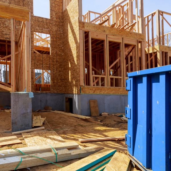 Old and used construction material in the new building frame of a new house under construction